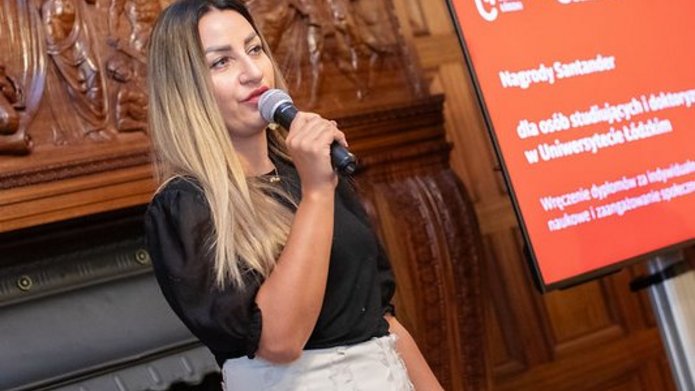 przedstawicielka firmy trzymająca mikrofon