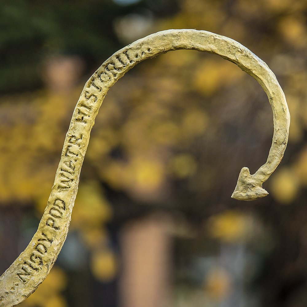 napis na rzeźbie - nigdy pod wiatr historii.. 