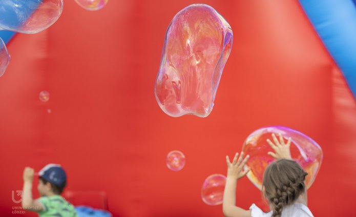 Children running among soap bubbles