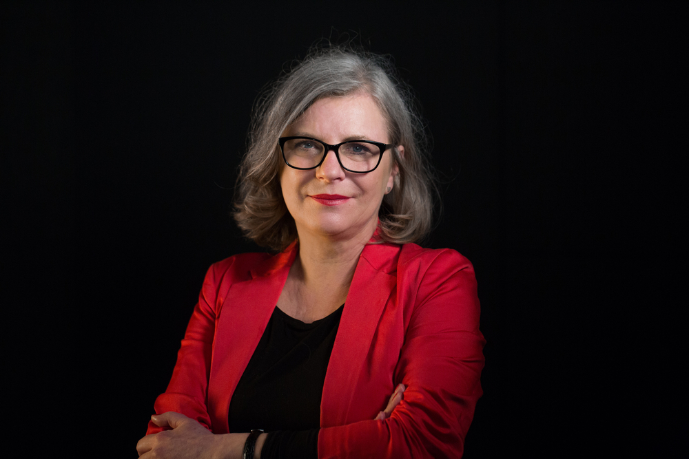 portret prof. D. Merecz-Kot w czerwonym żakiecie na czarnym tle