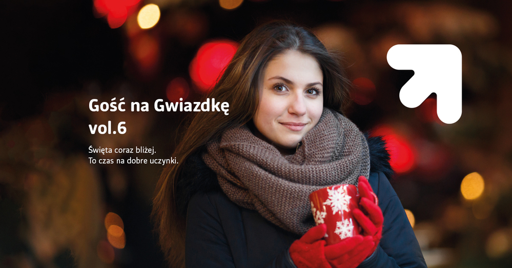 uśmiechnięta kobieta z ciemnymi długimi włosami trzymająca czerwony kubek z białymi płatkami śniegu