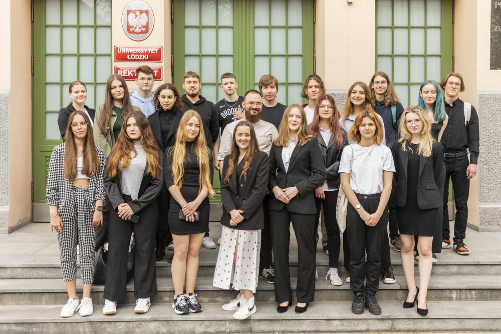 Uczniowie biorący udział w projekcie stoją przed budynkiem Rektoratu UŁ
