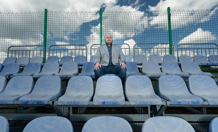 Prof. Michał Bijak siedzi na trybunach stadionu