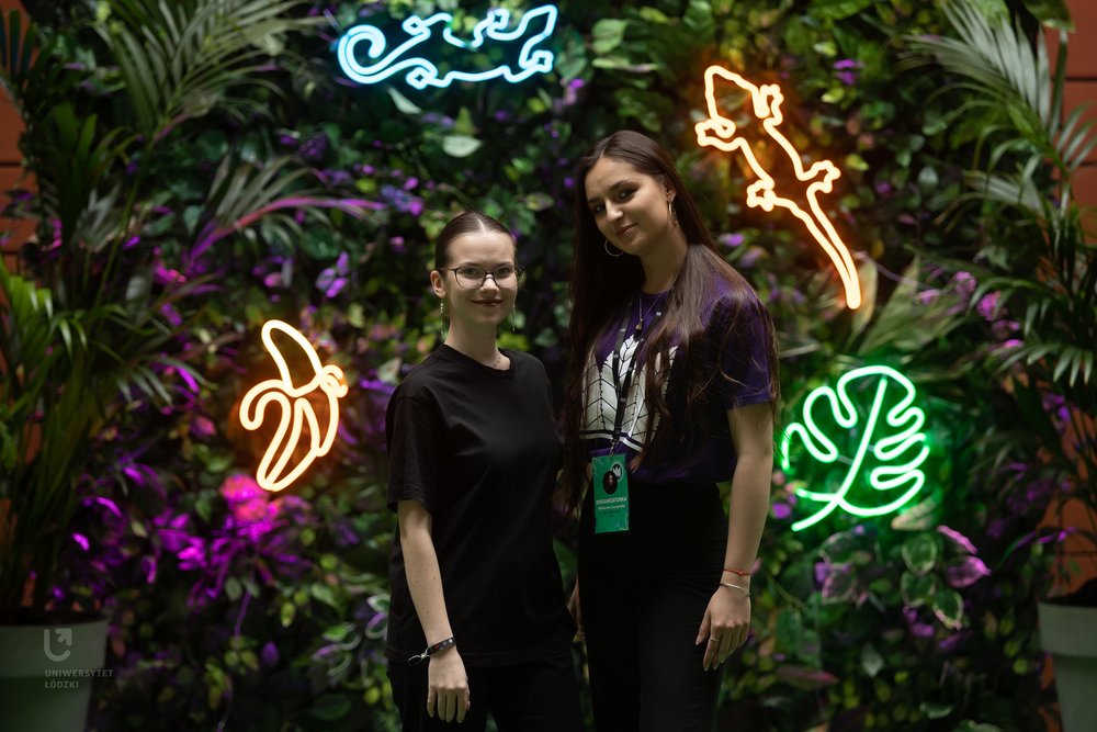 Aleksandra Kocik i Wiktoria Łuszczyńska na tle instalacji neonowej