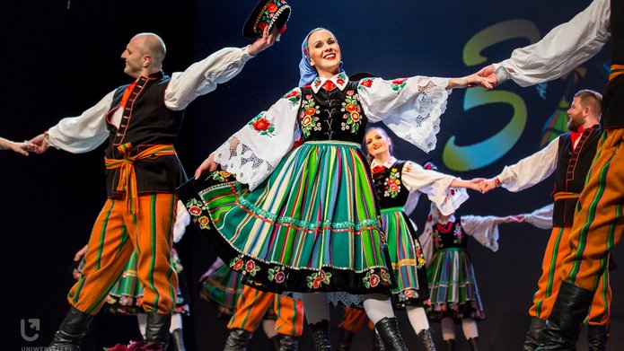 Akademicki Zespół Pieśni i Tańca Uniwersytetu Łódzkiego "KUJON" - tancerki i tancerze w strojach ludowych, tańczący na scenie