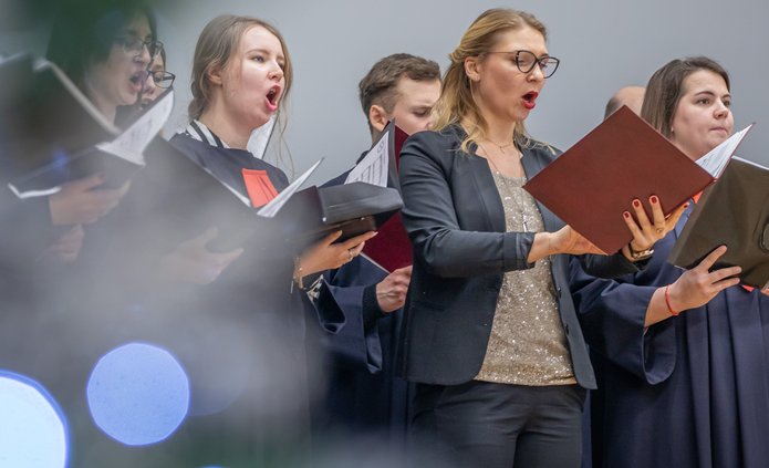 The University of Lodz Choir – women and men singing and holding sheet music 
