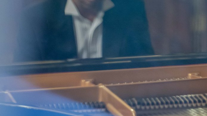 Mężczyzna w garniturze, grający na fortepianie