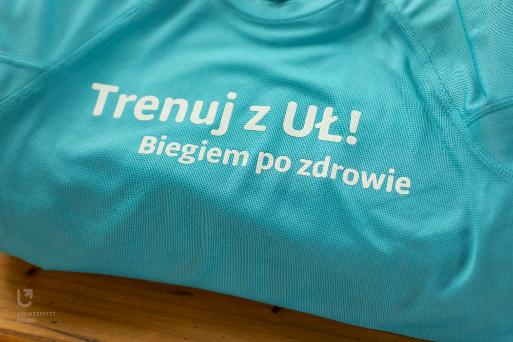 niebieska koszulka z napisem Trenuj z UŁ! Biegiem po zdrowie