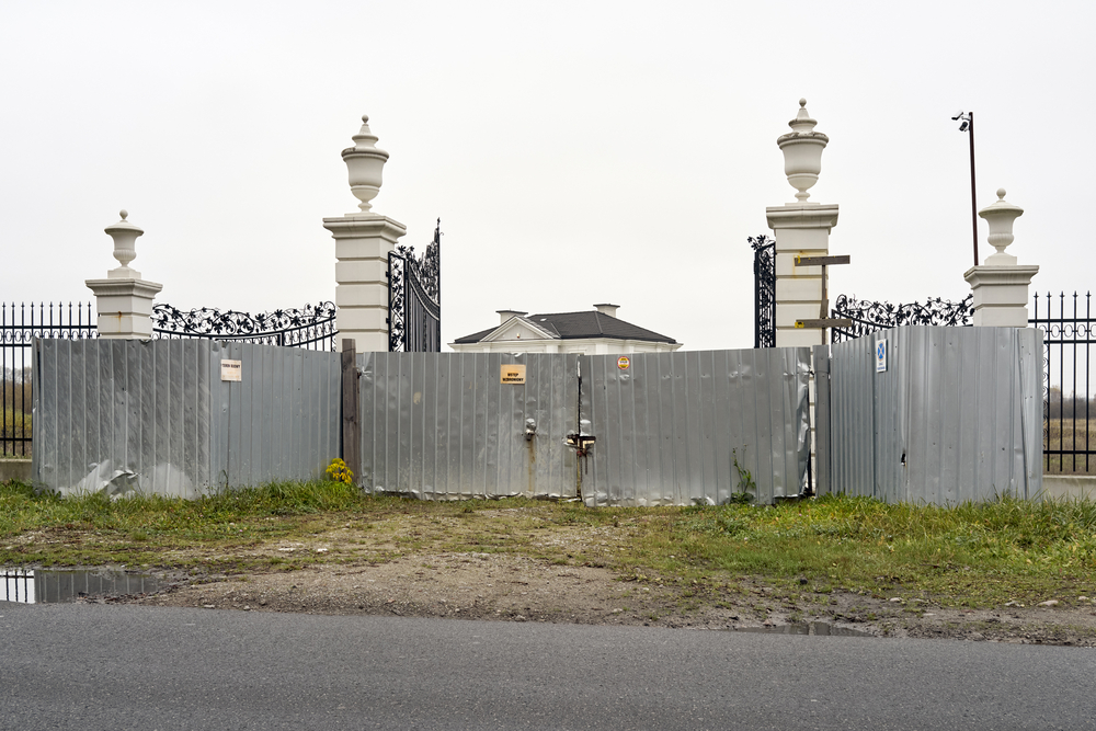 bogato zdobiony dom mieszkalny na przedmieściach zasłonięty tymczasową blachą na czas budowy bogato zdobiony dom mieszkalny na przedmieściach zasłonięty tymczasową blachą na czas budowy