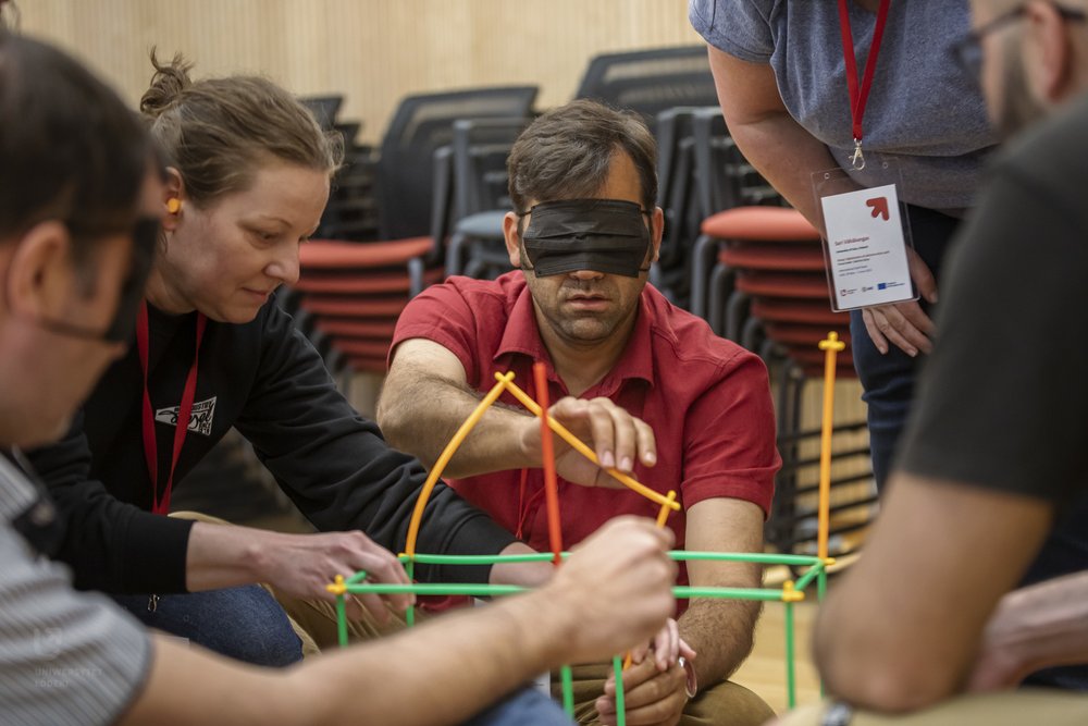 uczestnik spotkania podczas wykonywania zadania z zasłoniętymi oczami