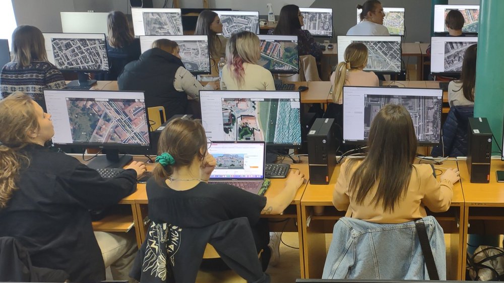 Sylwetki osób siedzących przy komputerach