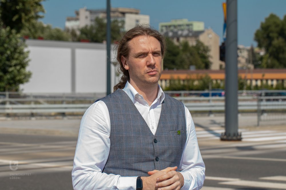 dr Szymon Wiśniewski pozuje do zdjęcia przy skrzyżowaniu ulic w Łodzi