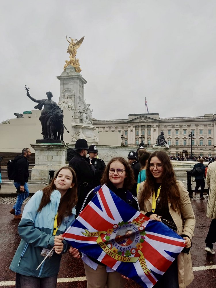 3 uczennice BISUL trzymające flagę brytyjską stojące na ulicach w Londynie