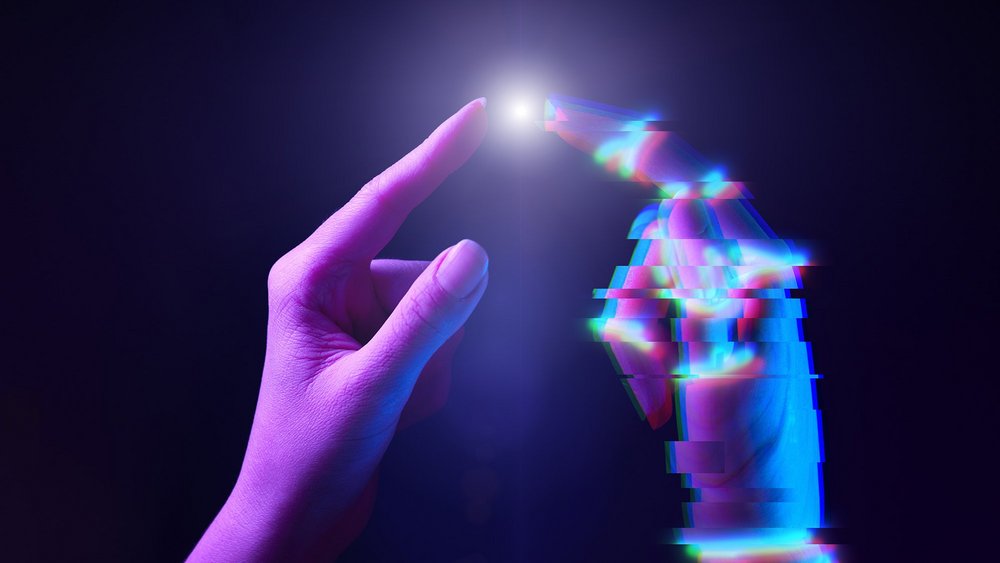 dwie dłonie stykające się palcami, jedna z cyfrowym efektem