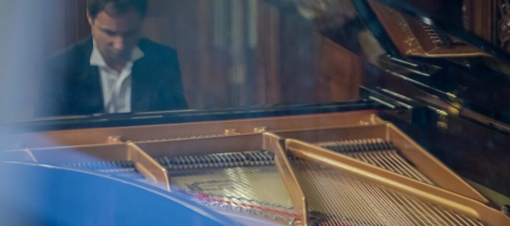 Mężczyzna w marynarce przy fortepianie