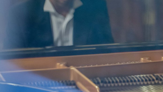 Mężczyzna w garniturze grający na fortepianie