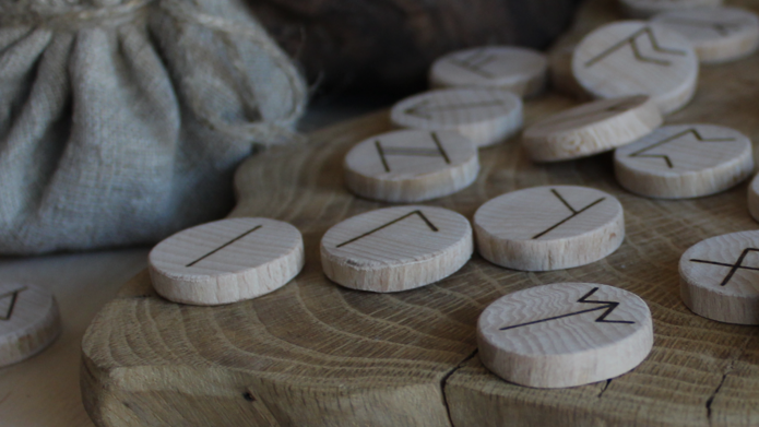 Worek, wokół którego leżą drewniane klocki z napisanymi znakami wikingów