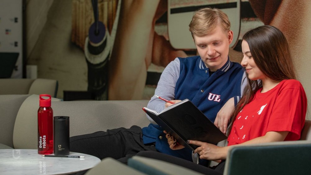 dwoje studentów dziewczyna i chłopak siedzą na sofie i coś czytają