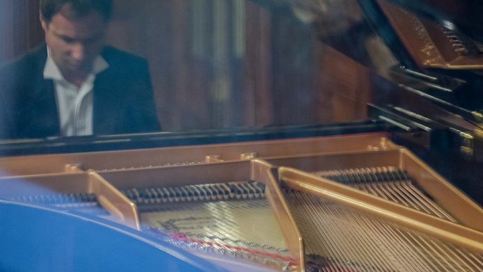 Mężczyzna siedzący przy fortepianie