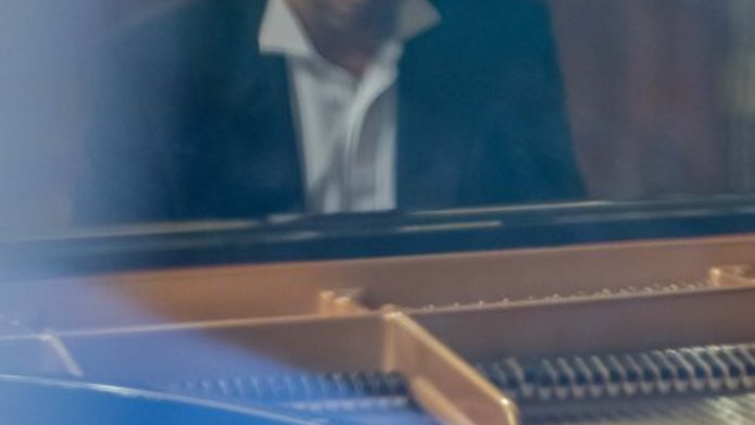 Mężczyzna siedzący przy fortepianie