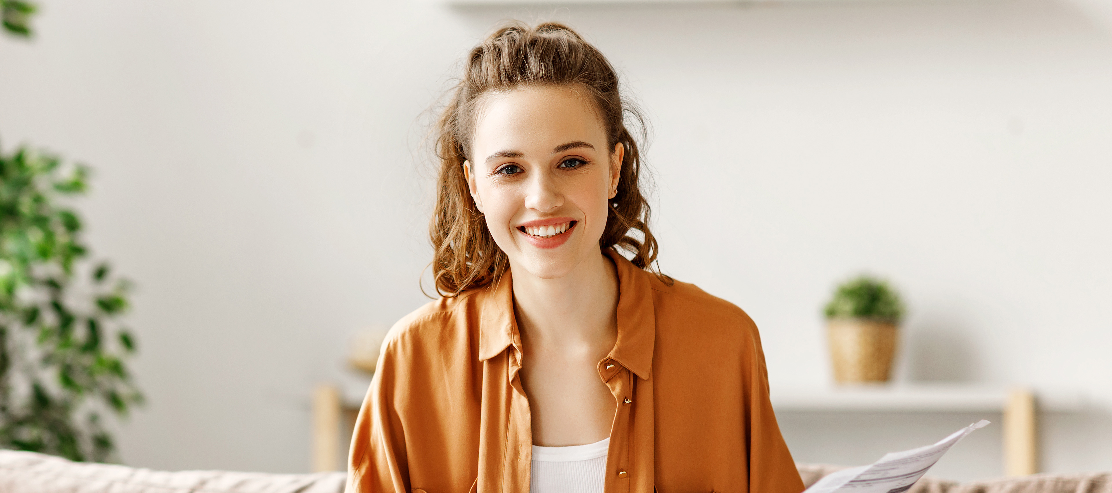 Uśmiechnięta dziewczyna na tle ściany z kwiatami