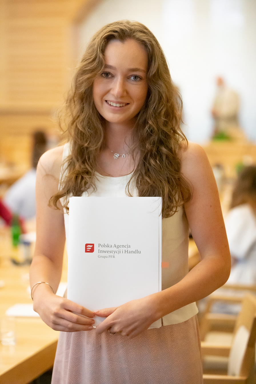 Studentka trzyma dyplom PAIH.