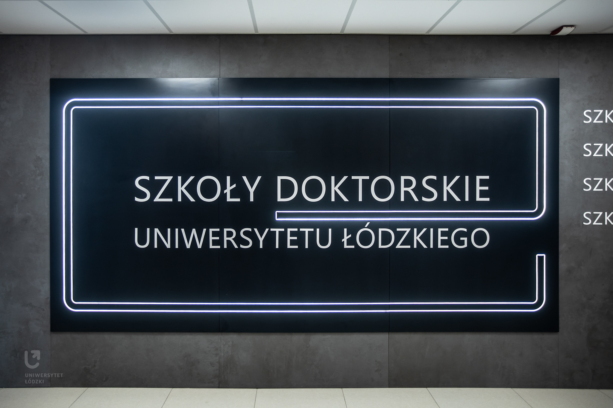 podświetlony napis na ścianie szkoły doktorskie UŁ