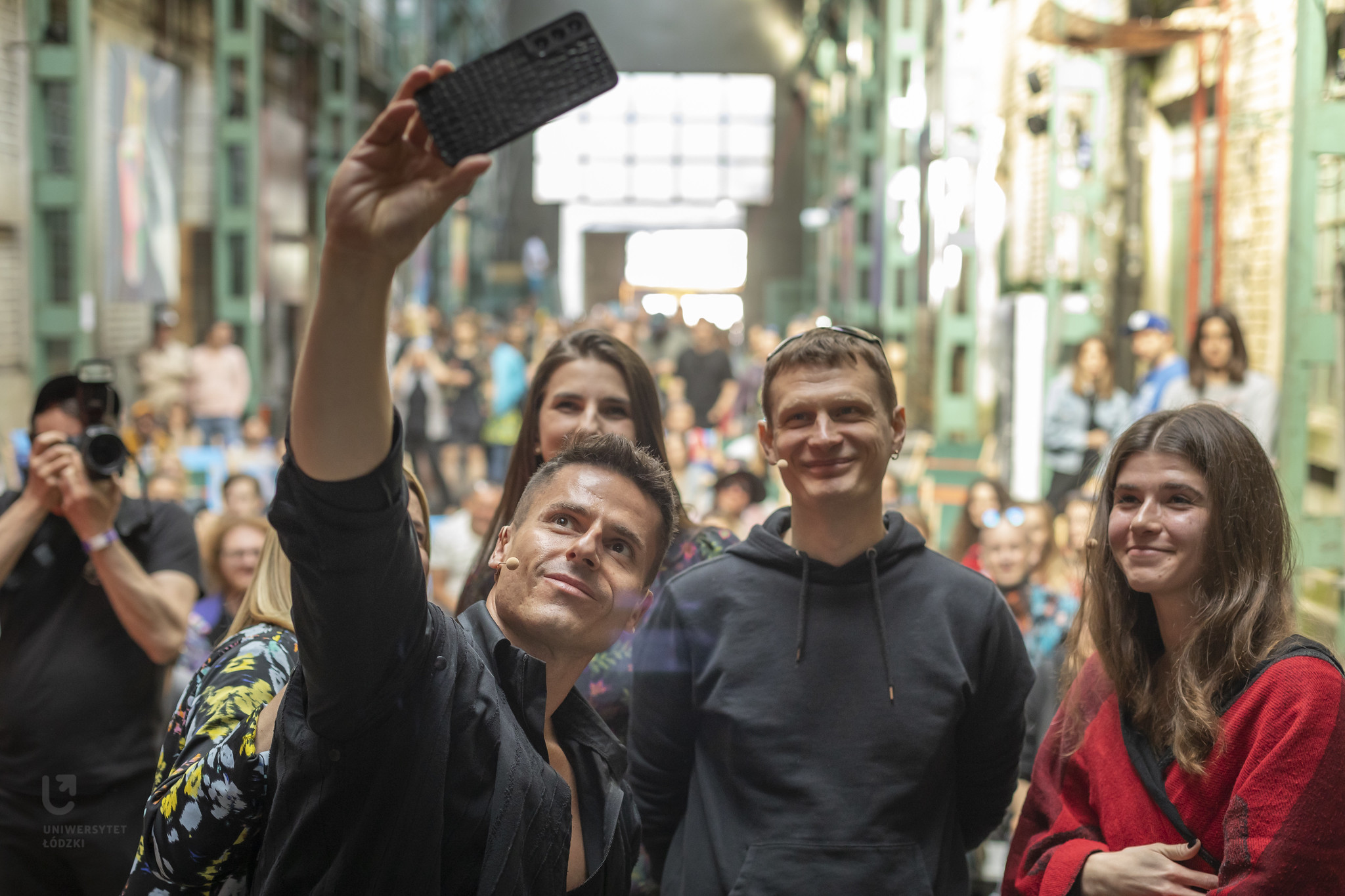 Grupa ludzi robiąca sobie wspólnie zdjęcie telefonem