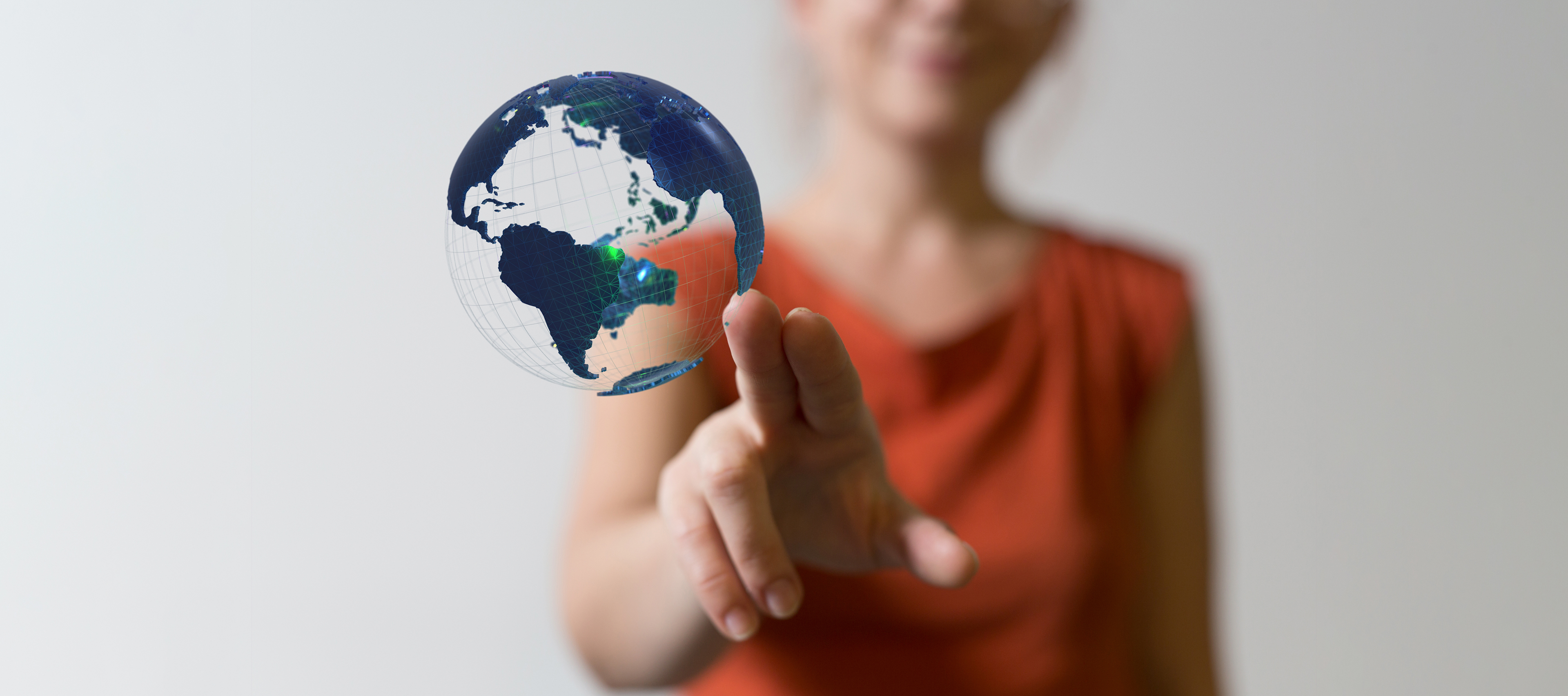 Postac kobiety dotykającej palcami grafiki pokazującej Ziemię