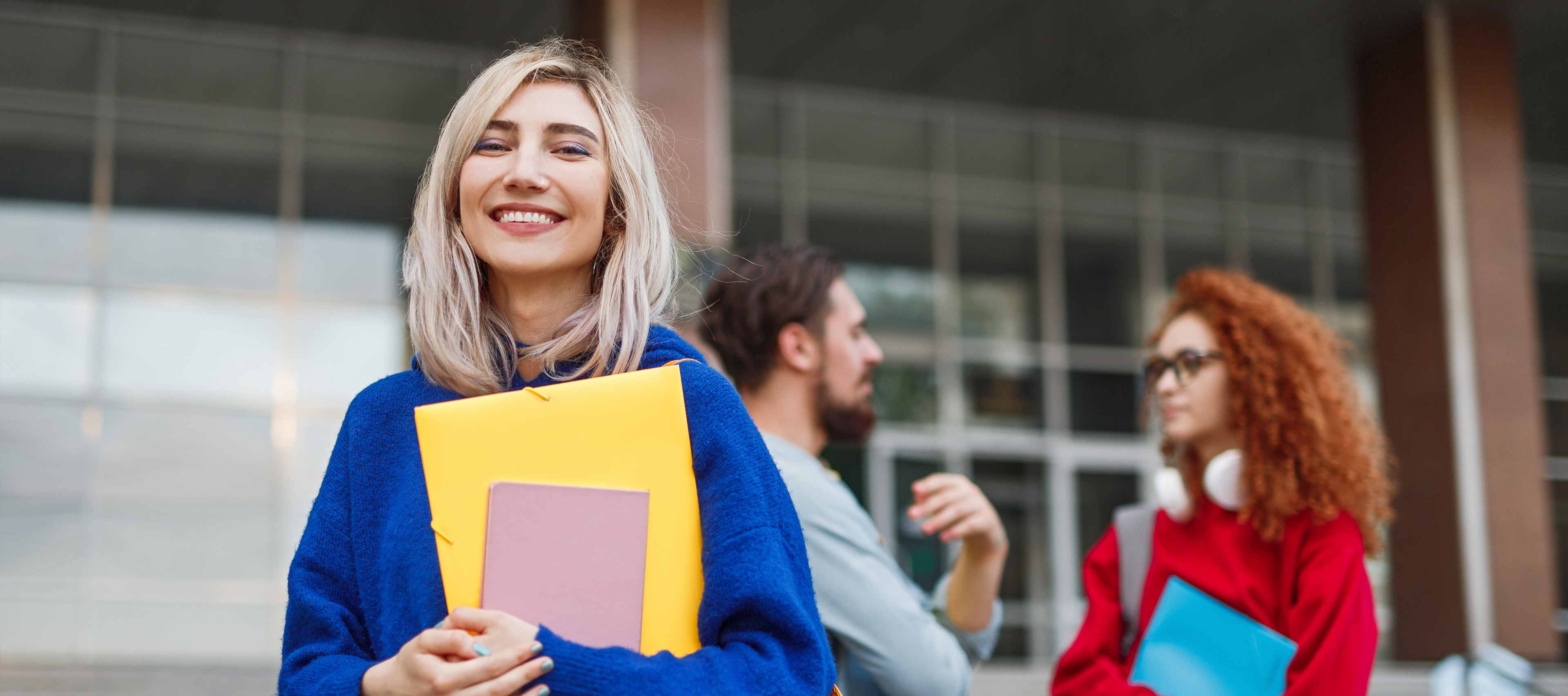 uśmiechnięta kobieta przed budynkiem