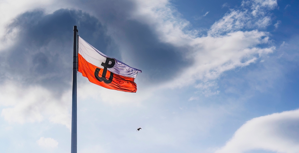 Polska flaga z symbolem Powstania Warszawskiego