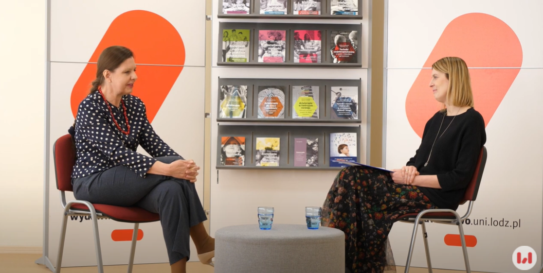 Kobieta w granatowym ubraniu siedząca na krześle