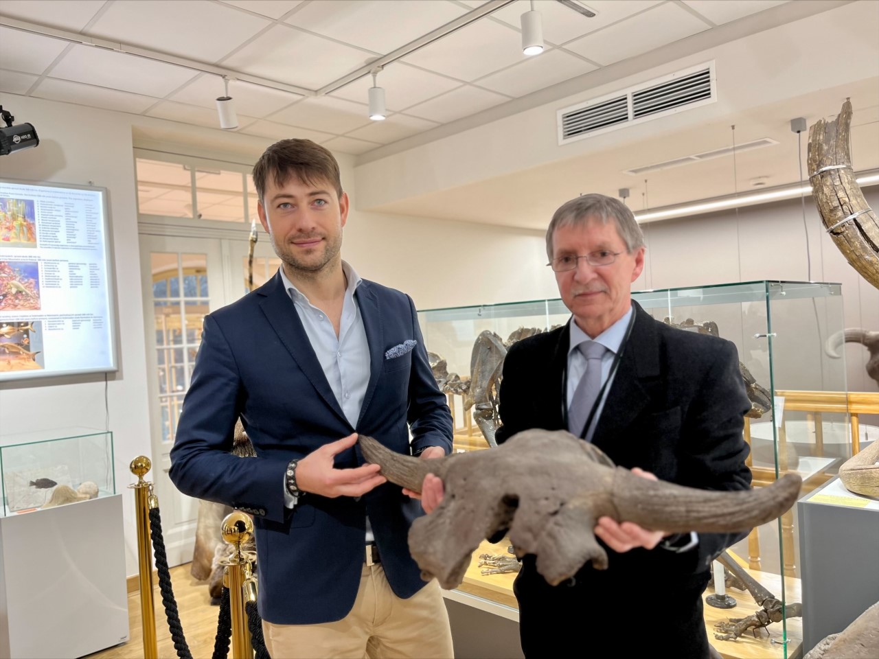 dwaj mężczyźni z czaszką pradawnego zwierzęcia