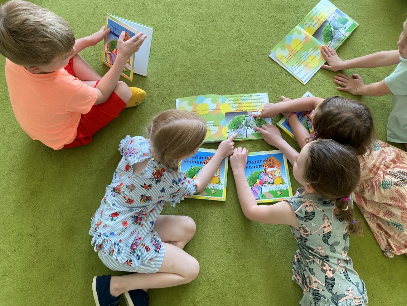 Dzieci przedszkolne czytające książeczkę