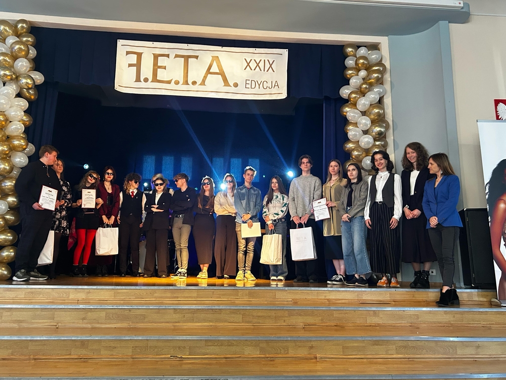 grupa ludzi stoi na scenie 