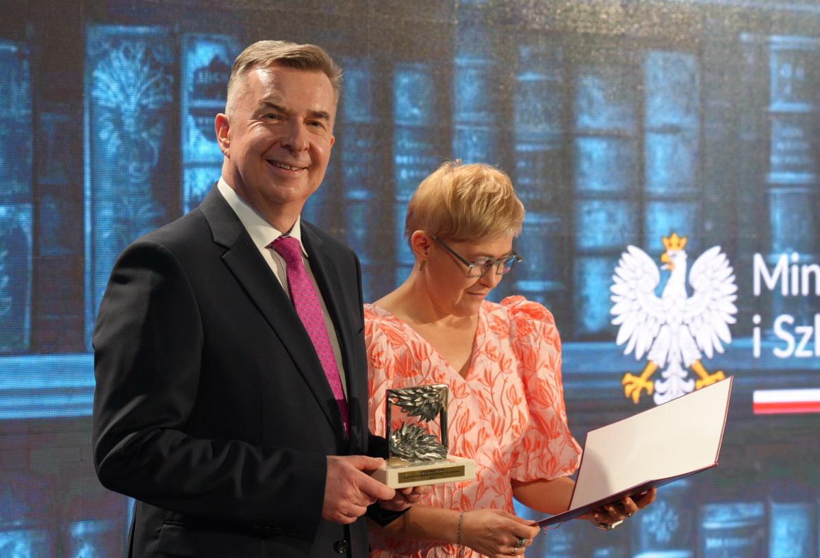 minister nauki stoi na scenie i uśmiecha się do zdjęcia 