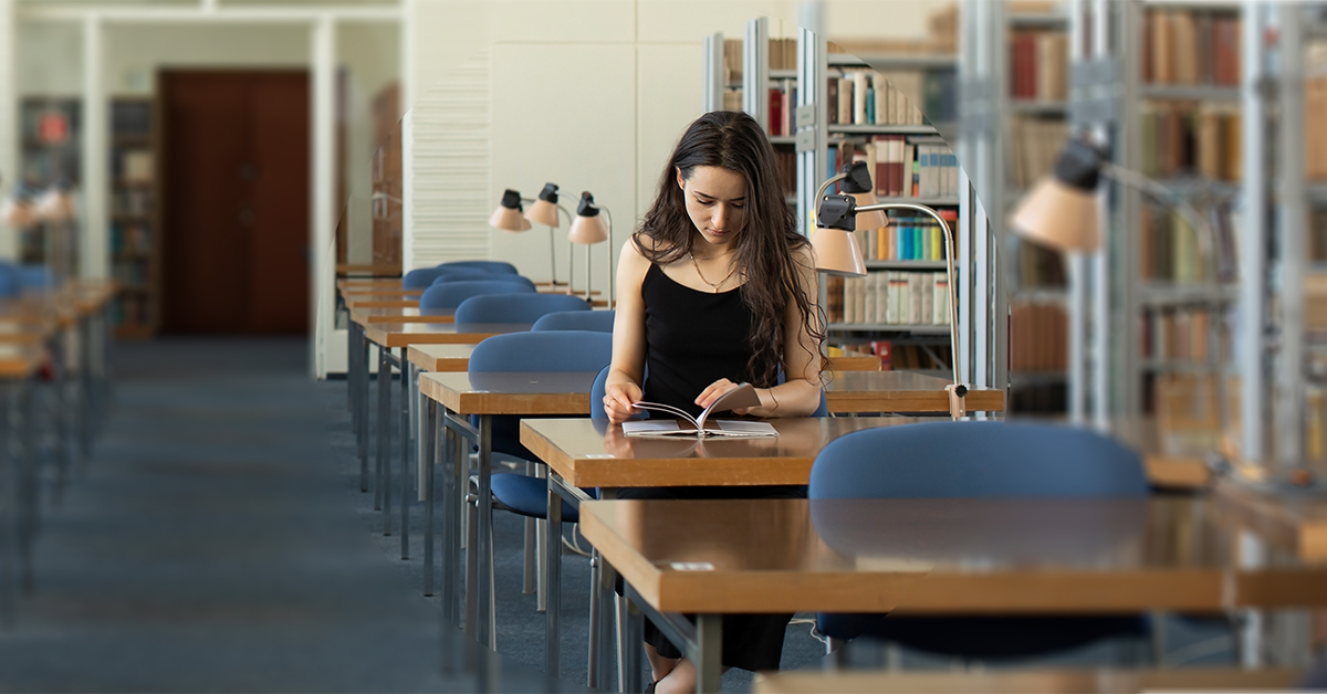 czytelnia biblioteczna, przy stole siedzi dziewczyna