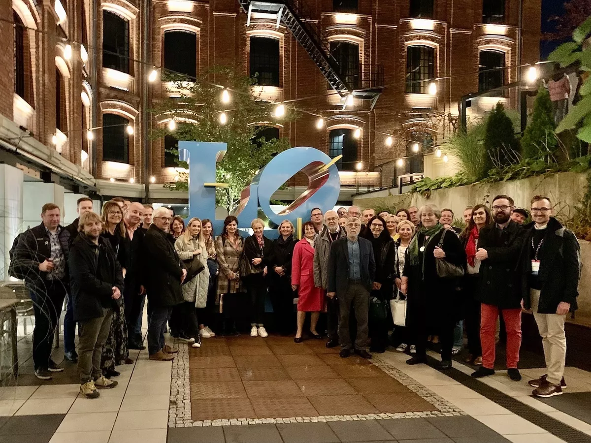 Zdjęcie grupowe uczestników konferencji na dziedzińcu Monopolis