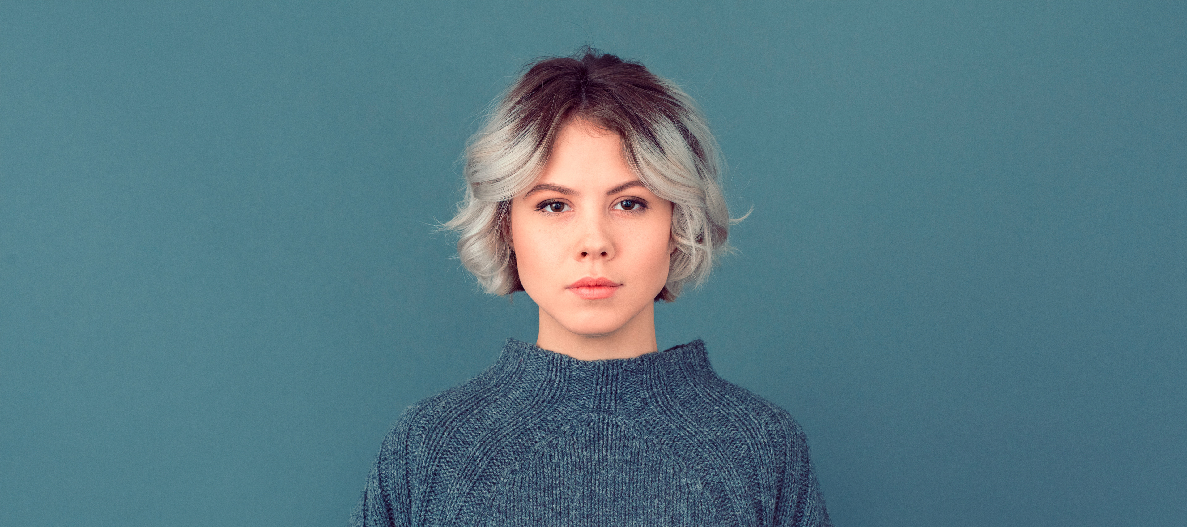 młoda kobieta z krótkimi włosami na niebieskim tle